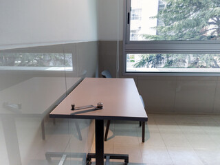 Table for eating near the window in a clean hospital room.