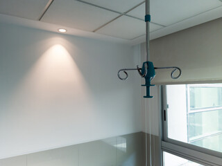Iv drip pole hanging in hospital patient room