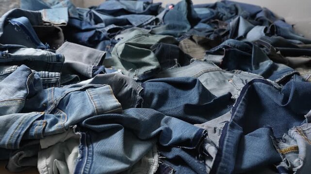 Denim clothing leftovers and fabric offcuts from jeans manufacturing. Apparel production process, textile industry waste and fashion manufacturing background