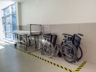 Wheelchairs and gurney in hospital hallway