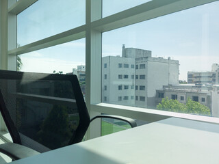 Empty office chair facing window with city view