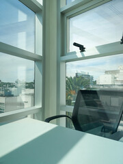 Empty office chair facing window with city view, vertical frame