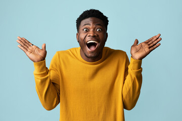 Surprised african american stylish young guy in yellow looking at camera with open mouth and...