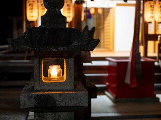 ロウソクの火が灯された石灯籠