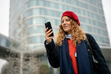 Woman checking smartphone in modern city exploring surroundings