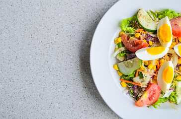 Top view of egg salad on the white plate. cruttong. mix salad. boiled egg. dressing. vegetables. high angle, above, flat lay. close up. granite table on the background. isolated. half. copy space