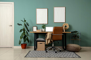 Interior of office with workplace, plants and blank frames