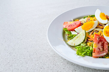 Half view of egg salad on the white plate. cruttong. mix salad. boiled egg. dressing. vegetables. close up. granite table on the background. isolated. half. copy space, empty, free, negative, text.