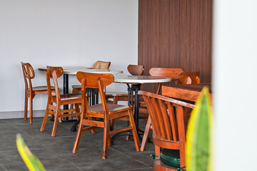 Empty tables And wooden chairs, grey or gray tables and chairs set. outdoor seating for restaurant, Cafe or coffee shop. Plants, leaves, green, nature, wall. wood. granite. brown. white. wall. decor, 