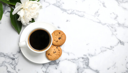 Top view of a black coffee cup with chocolate chip cookies on a white marble background, creating a cozy breakfast or coffee break atmosphere with clean space for text or design.