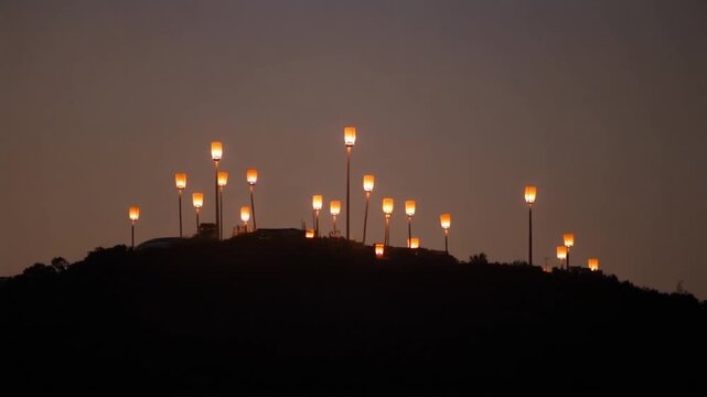 Nighttime industrial landscape with illuminated poles on a hill