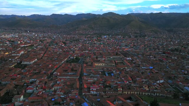 Plaza de Armas main town square vive en Peru Per&uacute; aerial drone cityscape red buildings Peruvian Andes landscape rainy season sunny daytime sunset clouds Inca Empire capitol forward pan up motion