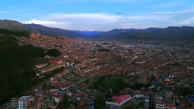 Cusco Plaza de Armas vive en Peru Per&uacute; aerial drone Cuzco Saqsaywaman cityscape red buildings Peruvian Andes landscape rainy season daytime sunset blue sky could Inca Empire capitol forward pan up
