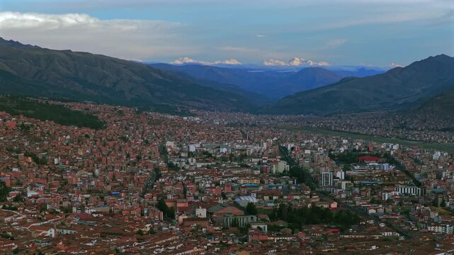 Cusco Plaza de Armas Peru Per&uacute; aerial drone Cuzco international airport cityscape red buildings Peruvian Andes landscape rainy season sunset blue sky could Inca Empire capitol forward pan up motion