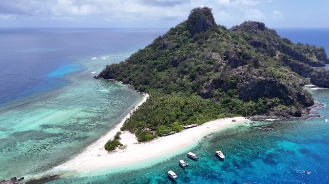 Exquisite aerial drone view of a pristine white sand beach on Castaway Island, Fiji. Vibrant turquoise waters and healthy coral reefs surround this secluded South Pacific paradise.