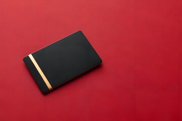 Black gift card with gold stripe on red background symbolizing luxury, minimalism and premium style. Clean composition perfect for gift cards, branding, promotions and elegant design.