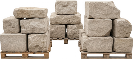 Stacked light beige rough cut stone blocks and rough hewn quarried rock pieces are arranged on wooden pallets ready for construction building material quarry material natural stone