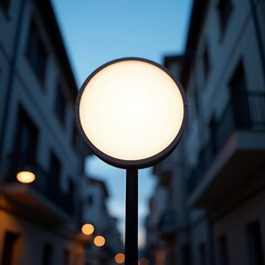 A round street light stands tall in a quiet urban alleyway at dusk