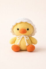 A cute crocheted chick with a white bonnet sits pretty. The little ducky is bright and yellow, adding a touch of handmade charm to any room.