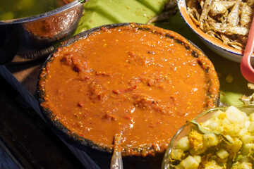 Assorted traditional Indonesian dishes with vibrant homemade flavors, mixed vegetables, fried fish, savory side dishes, and rustic market-style presentation, rich cultural culinary visuals