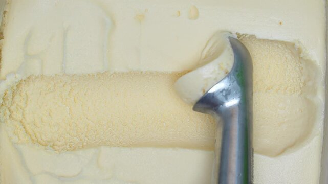 4K vanilla ice cream with metal scoop creating smooth texture and soft curves, Concept of dessert frozen food sweetness refreshment minimal food background and delicious cold treat.