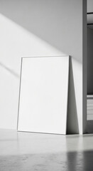 Minimalist poster mockup leaning against a wall on a clean floor, contemporary interior setting, natural soft lighting