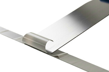 Metal putty knife removing strip of white tape from the surface isolated with transparent background