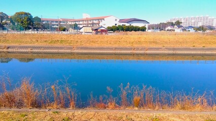 青空を映す冬の朝の坂川放水路風景