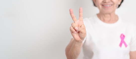 Elderly woman with pink Ribbon for Pink October Breast Cancer Awareness month, May Women Health, February World cancer day, support people life and illness. National cancer survivors month