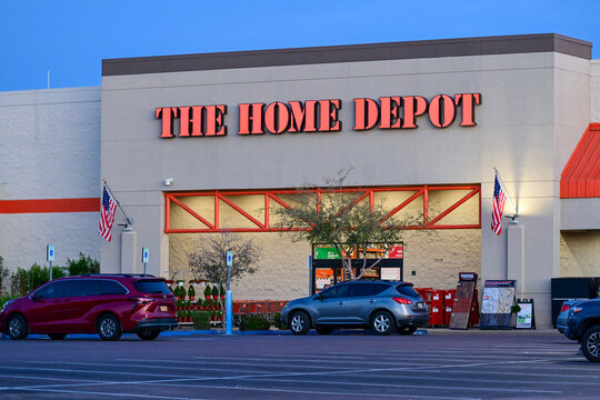 Exterior view of a Home Depot home improvement retail store with branded signage and customer entrance, representing big box retail operations for building materials and home improvement supplies