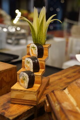 Three pieces of sushi elegantly arranged on a wooden serving board. The fresh ingredients and clean presentation highlight traditional Japanese cuisine with a natural, rustic touch.