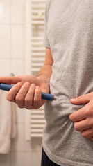 Man injecting insulin with a medical pen. Close up of diabetic patient administering medication. Healthcare and diabetes management concept