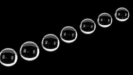 A diagonal line of eight clear glass marbles on a black background.