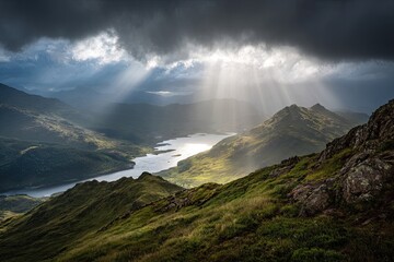 Mountain landscape with sunlight breaking through storm clouds over a lake