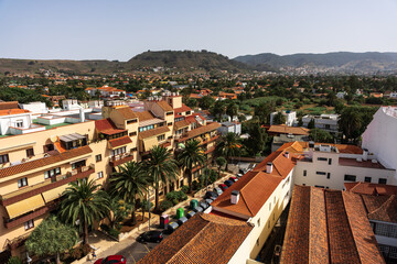Cityscape view from church bell tower, red tile rooftops and palm trees in La Laguna, San Cristobal de La Laguna, Tenerife.