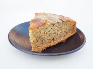 The banana cake was placed on a plate. It smelled wonderful and looked and tasted delicious.