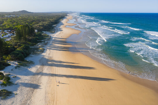 Aerial view of waves and sand patterns on a golden sand beach