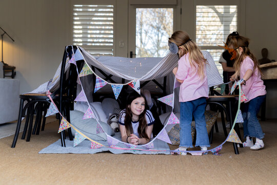 Young girls wearing animal masks setting up the buntings around makeshift tent