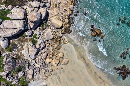 Aerial image capturing the turquoise waters and rocky shoreline of Rose Bay, Bowen