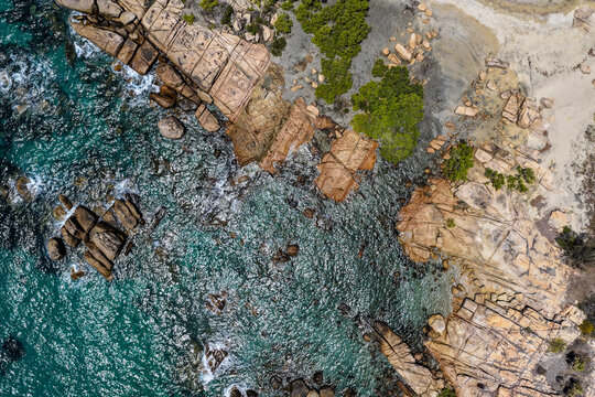 Aerial image capturing the turquoise waters and rocky shoreline of Rose Bay, Bowen