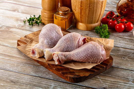 Fresh raw chicken drumstick over board
