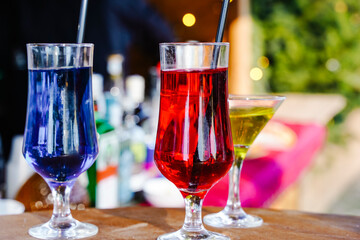 Assorted Colorful Fruit Cocktails with Straws and Garnish on a Bar Counter