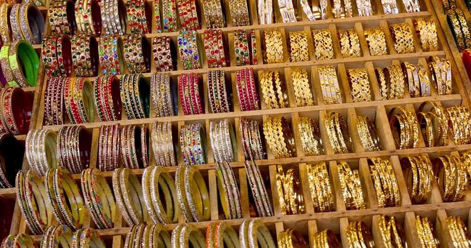 Assorted traditional Rajasthani style colorful ladies bangles and bracelets are arranged in the racks for sale on the street market