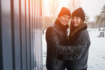 Joyful Lovers Embracing In Snowy City Scenery, Happy Pair Sharing Warmth During Cold Winter In Urban Environment, Lovers In Cold Weather Cuddle Tightly Beneath Snowy City Skyline With Joy