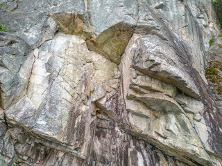Rugged Cliff Face With Layered Stones and Cracked Rock Formations Along a Coastline
