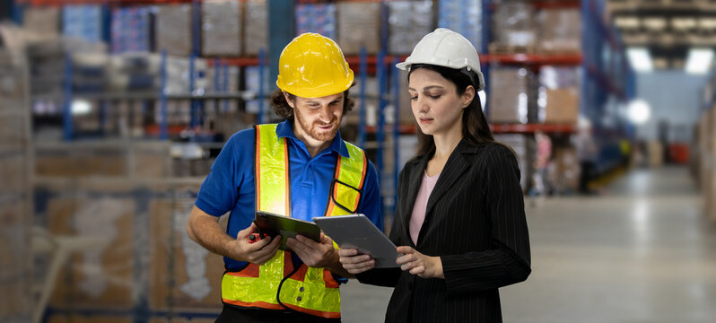 Warehouse manager and logistics worker collaborating with digital tablets in storage facility, showcasing teamwork, technology integration. - Powered by Adobe