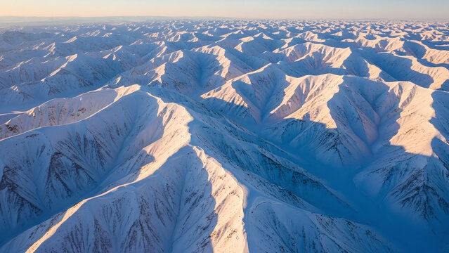 Breathtaking aerial view of snow-covered mountain range at sunrise, creating serene atmosphere with natural lighting and warm tones - Powered by Adobe