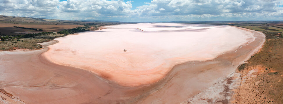 Aerial panoramic view over a large pink salt lake