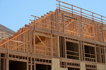 Construction shows wooden framework against blue sky. Construction residential building. Construction reveals structural details as it rises. Construction defines modern development with its frame.