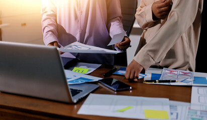 Close up ux developer and ui designer brainstorming about mobile app interface wireframe design on table with customer breif and color code at modern office.Creative digital development agency.